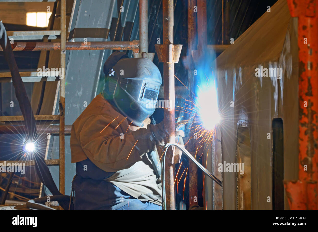 a welder working at shipyard in day time Stock Photo