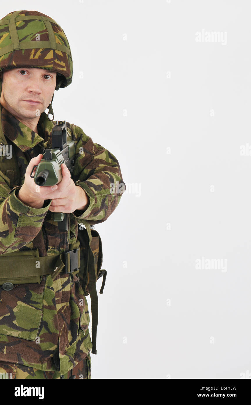 British soldier in green camouflage uniform taking aim with SA80 rifle. Stock Photo