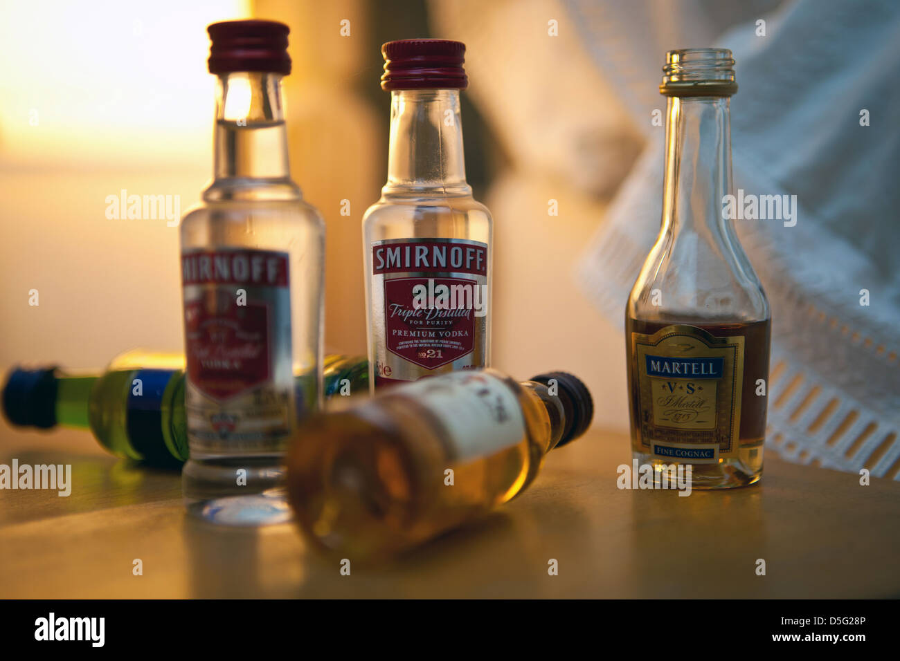 Miniature bottles of alcoholic drinks from hotel mini-bar on bedside table Stock Photo