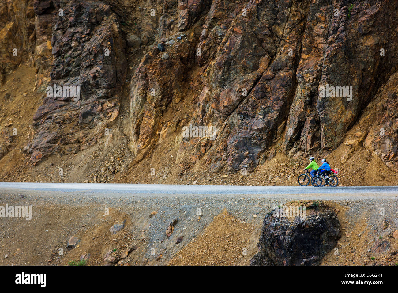 Two female tourists ride bicycles on the limited access Denali Park Road, Denali National Park, Alaska, USA Stock Photo