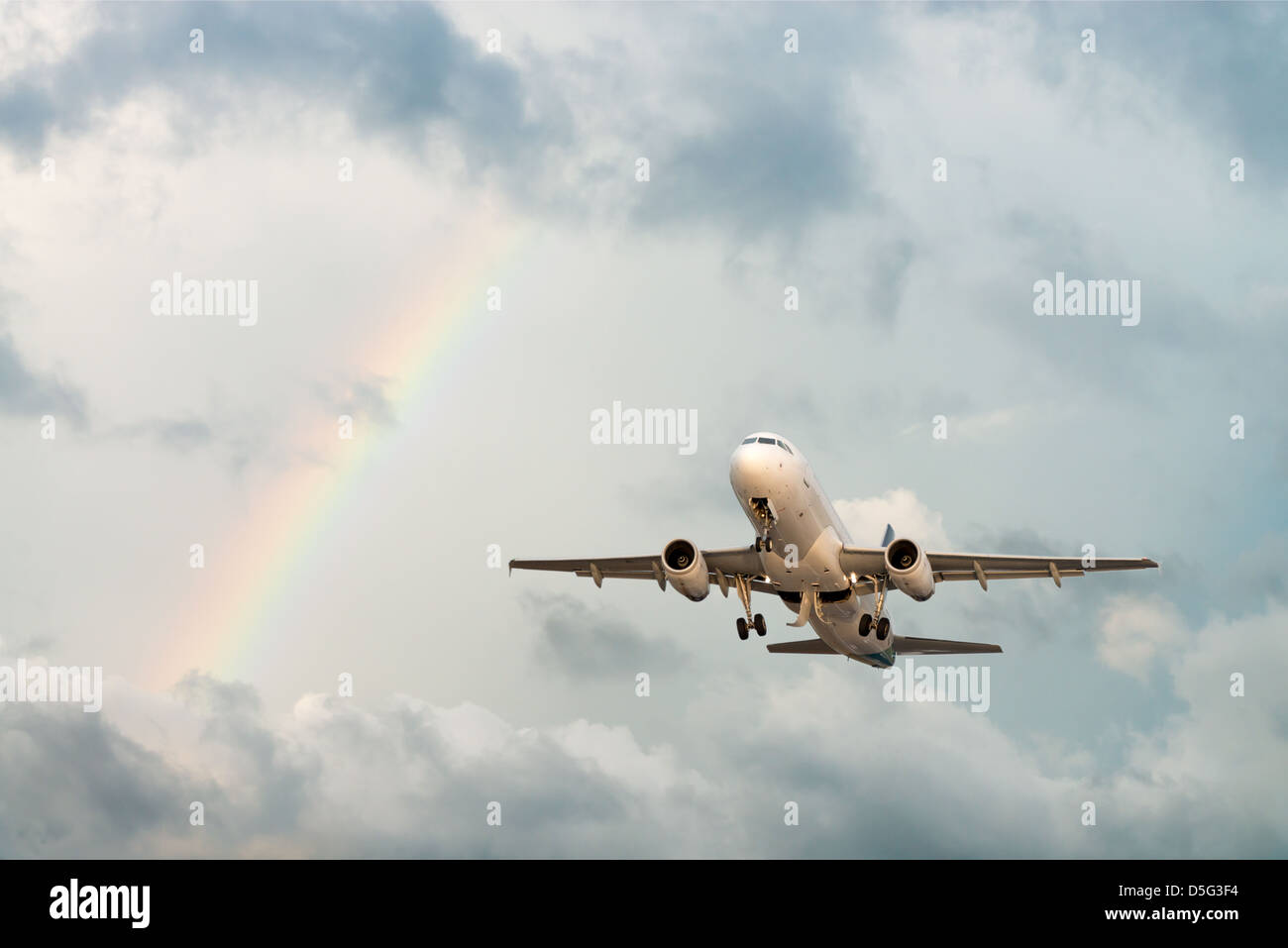 Airplane flying in cloudy sky with rainbow after rain Stock Photo - Alamy