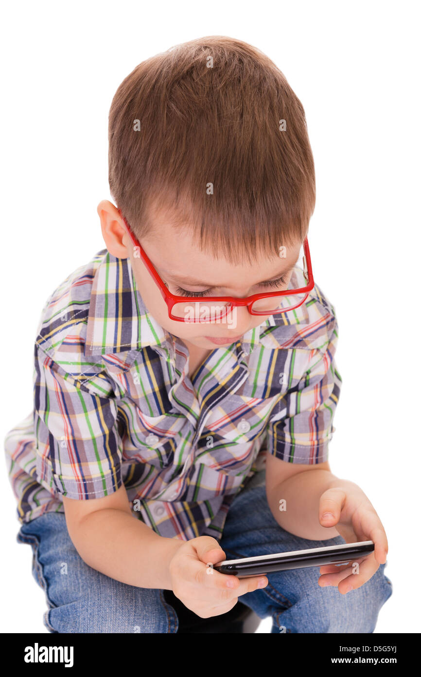 Clever small boy plays with his touch smartphone isolated on white background Stock Photo