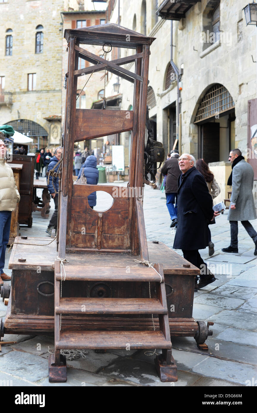 Man looks at a guillotine at the Antique market Arezzo Italy Stock Photo