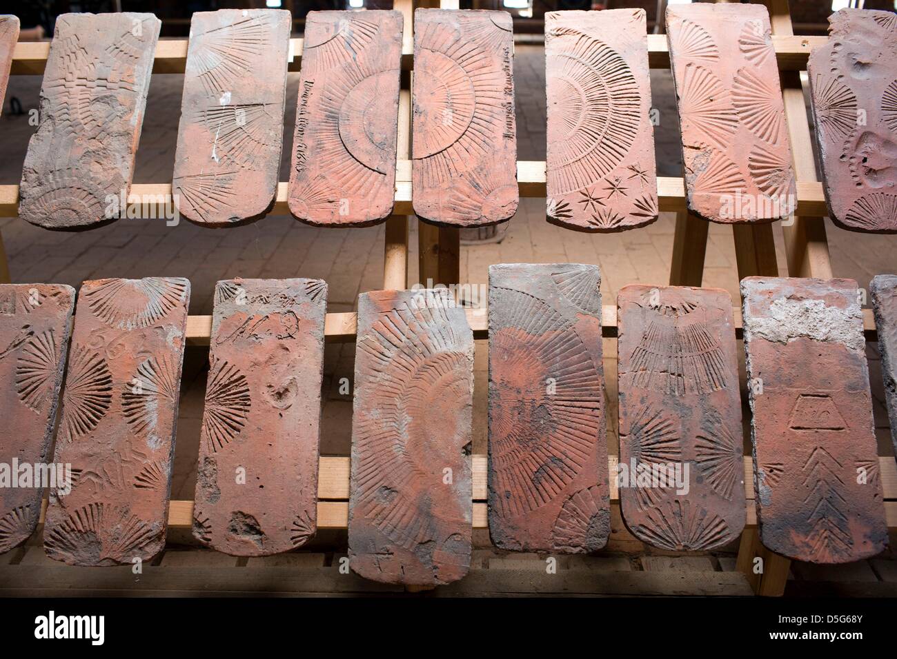 Specially decorated roof tiles are on display at the museum of the brick manufacture in Benzin, Germany, 26 March 2013. The more than 100 year old plant has been restaured in recent years and now prodcues bricks, sheets and plasters from clay according to old techniques. As a living museum it informs visitors about the traditions of once more than 400 brickyards in Mecklenburg. Photo: Jens Buettner Stock Photo