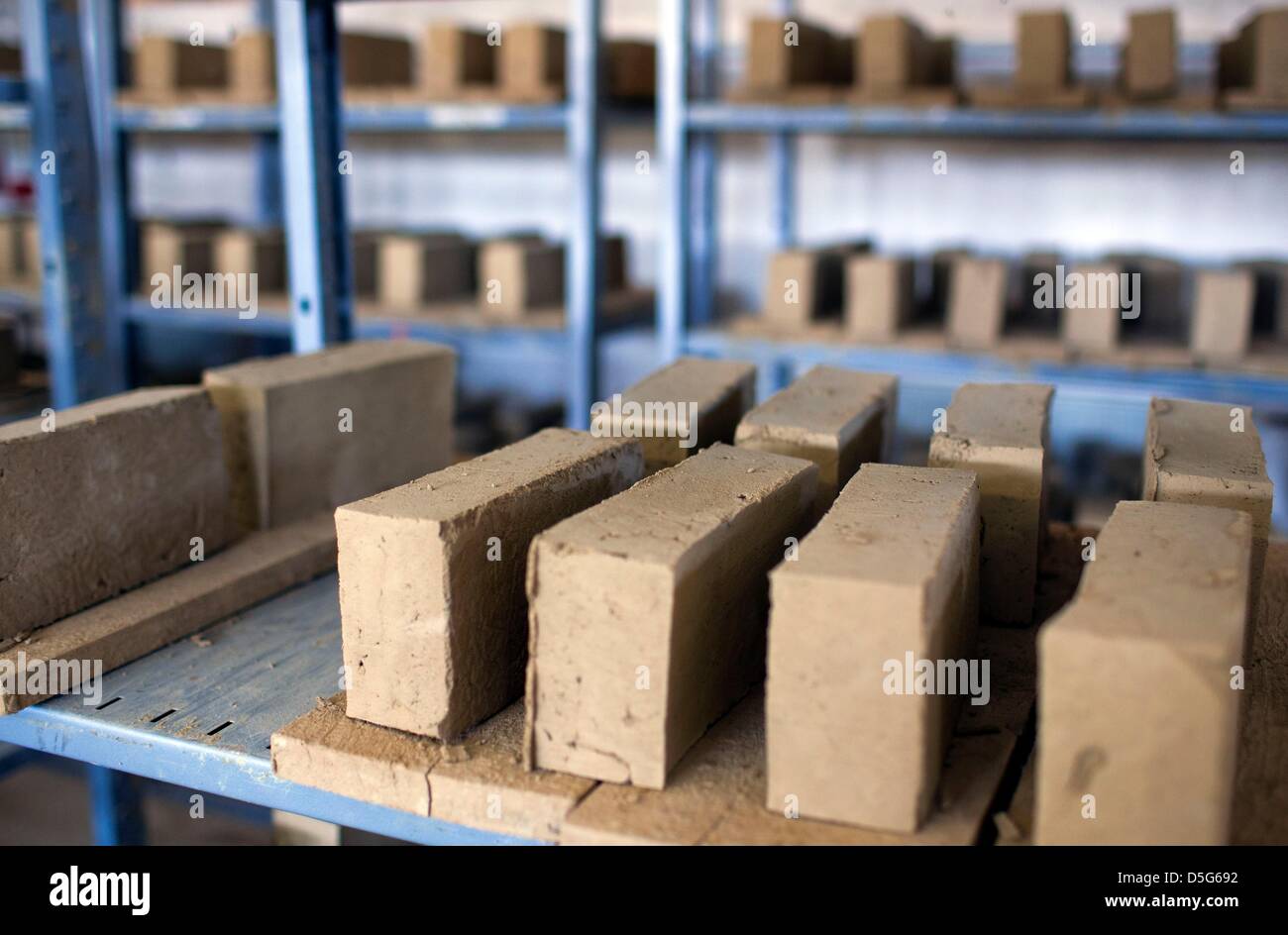 Clay bricks lie in a shelf to dry at the brick manufacture in Benzin, Germany, 26 March 2013. The more than 100 year old plant has been restaured in recent years and now prodcues bricks, sheets and plasters from clay according to old techniques. As a living museum it informs visitors about the traditions of once more than 400 brickyards in Mecklenburg. Photo: Jens Buettner Stock Photo