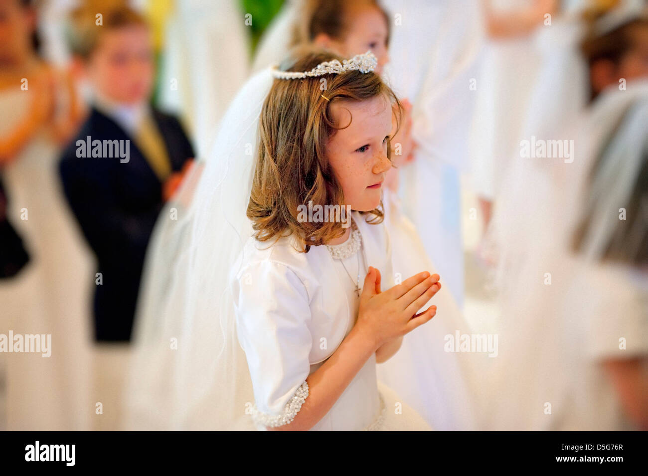 Girl receiving the sacrament of communion. Stock Photo