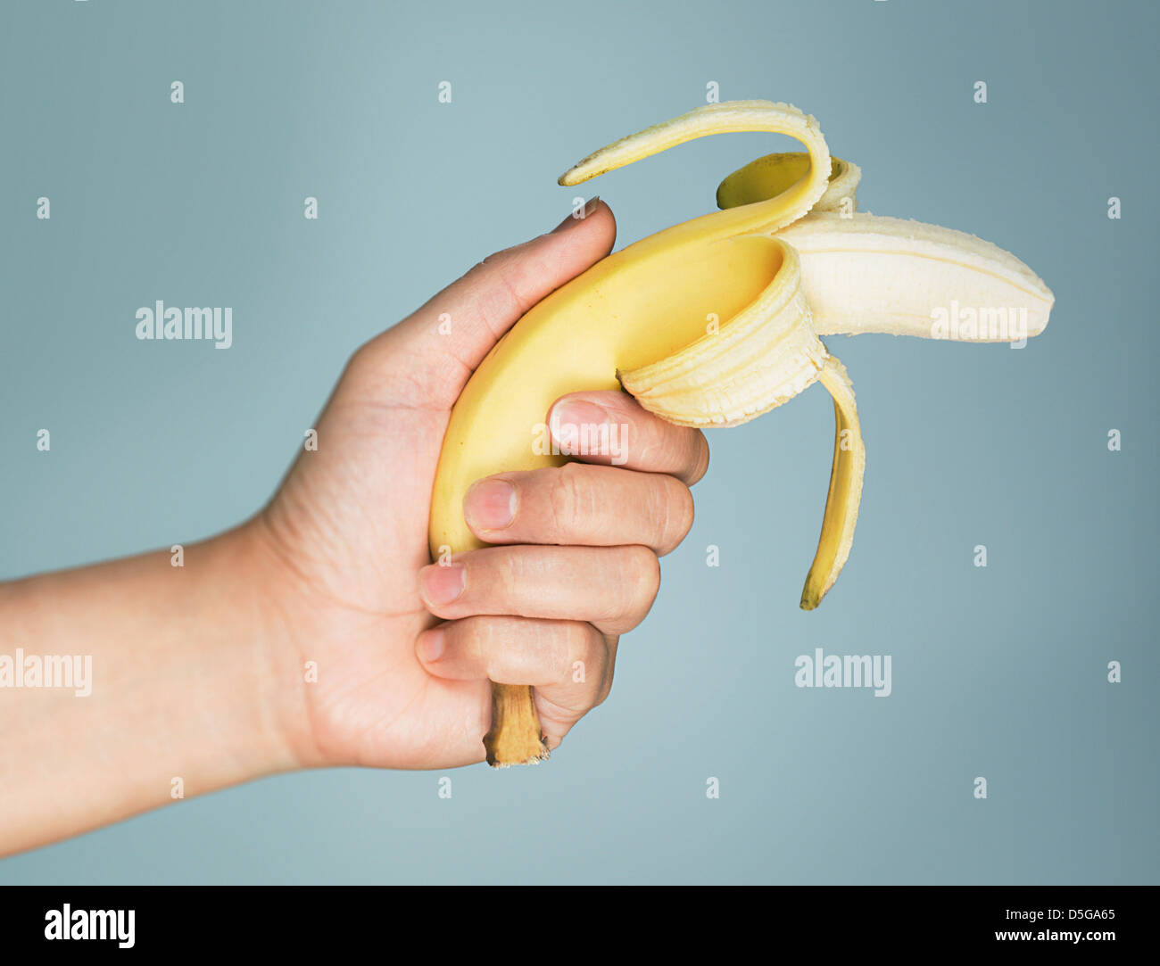 A banana is pointed like a gun with its end peeled back in a comedic  fashion Stock Photo - Alamy