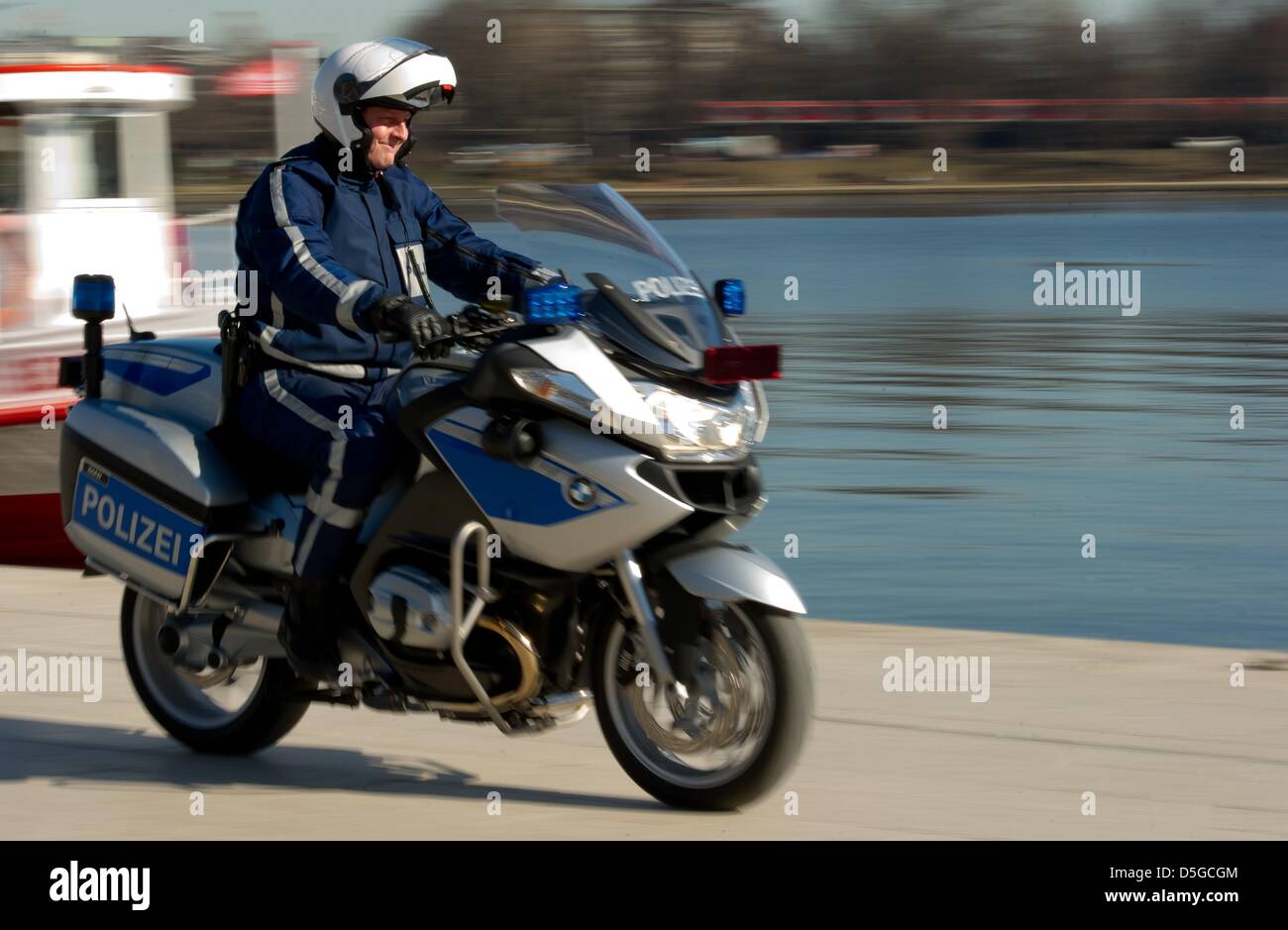 A police officer cruises on his new motorcycle around the Binnenalster