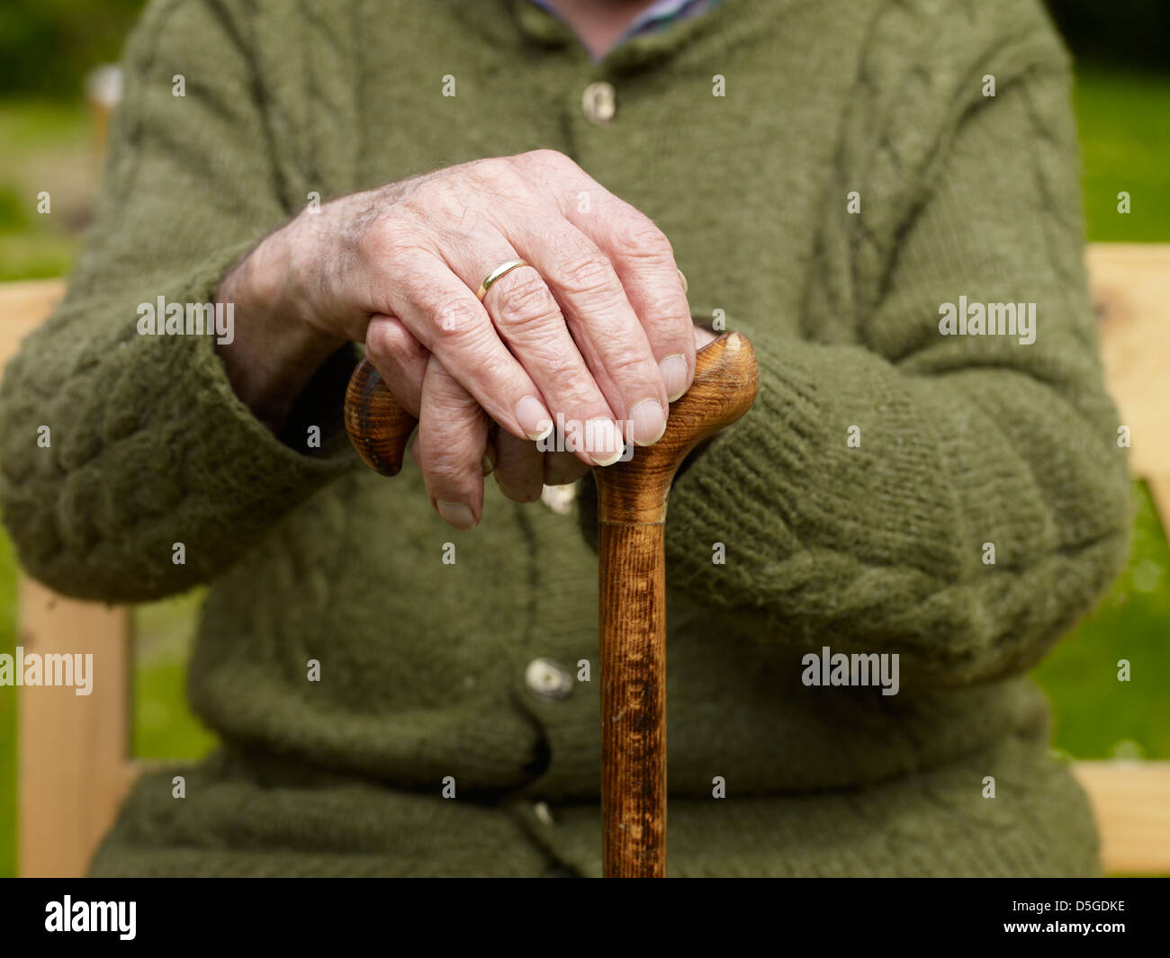 old hands of a senior on walking stick Stock Photo