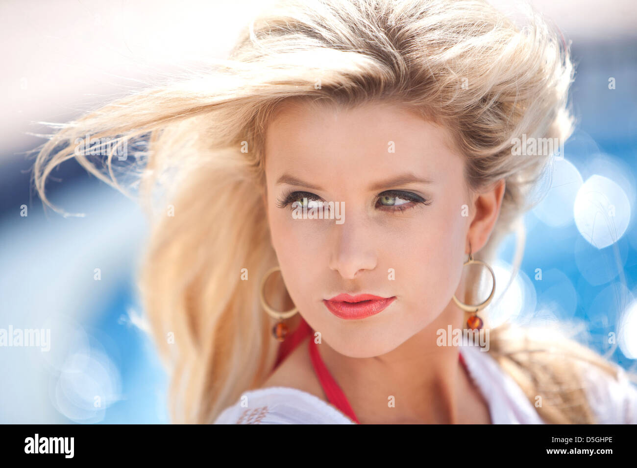 Woman with wind blown hair in front of pool Stock Photo