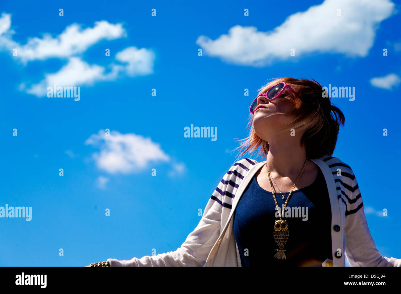 Woman white sweater blue dress against blue sky Stock Photo