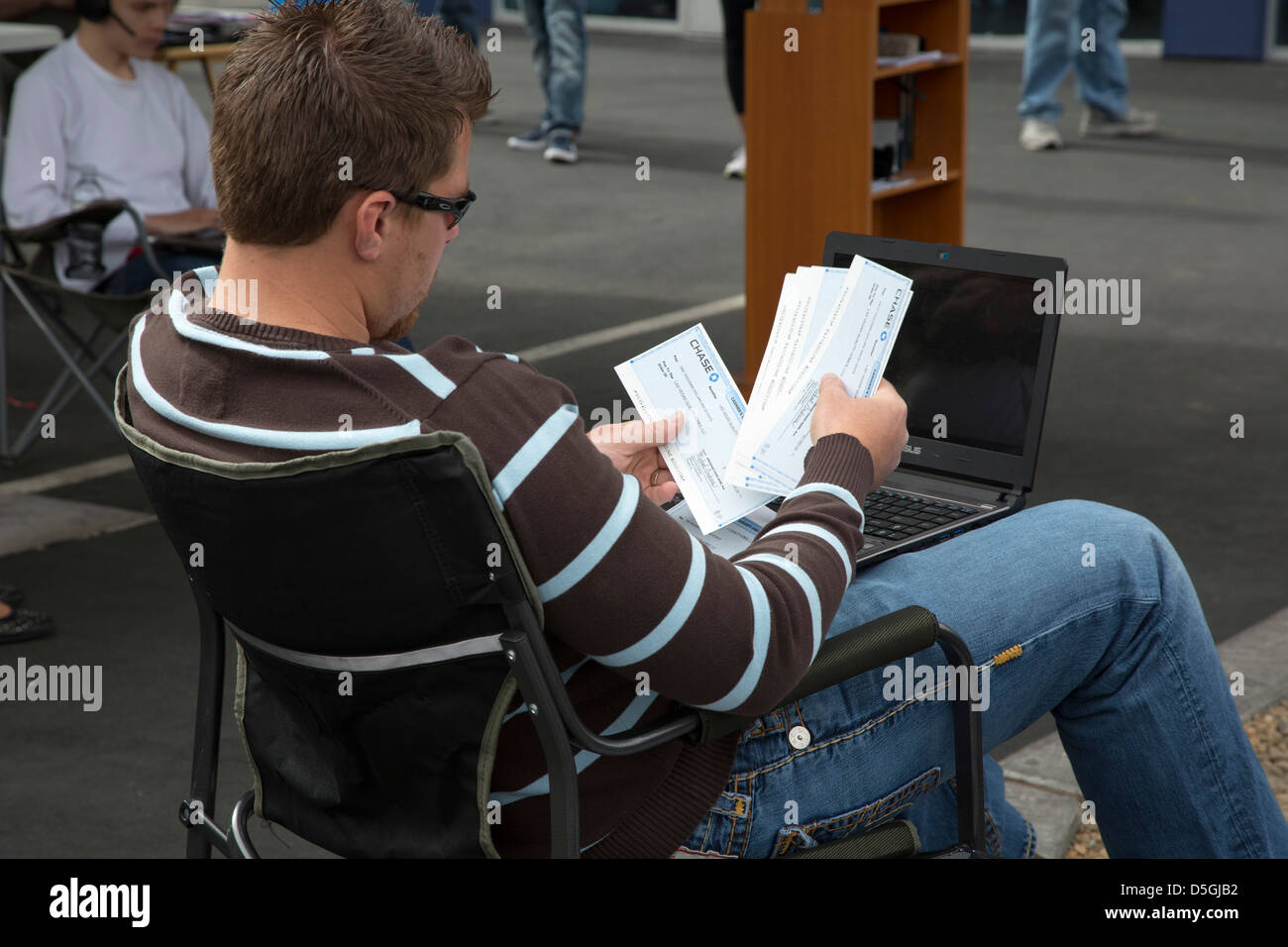 A bidder looks over cashier's checks he hopes to use to buy foreclosed homes during a Las Vegas auction. Stock Photo