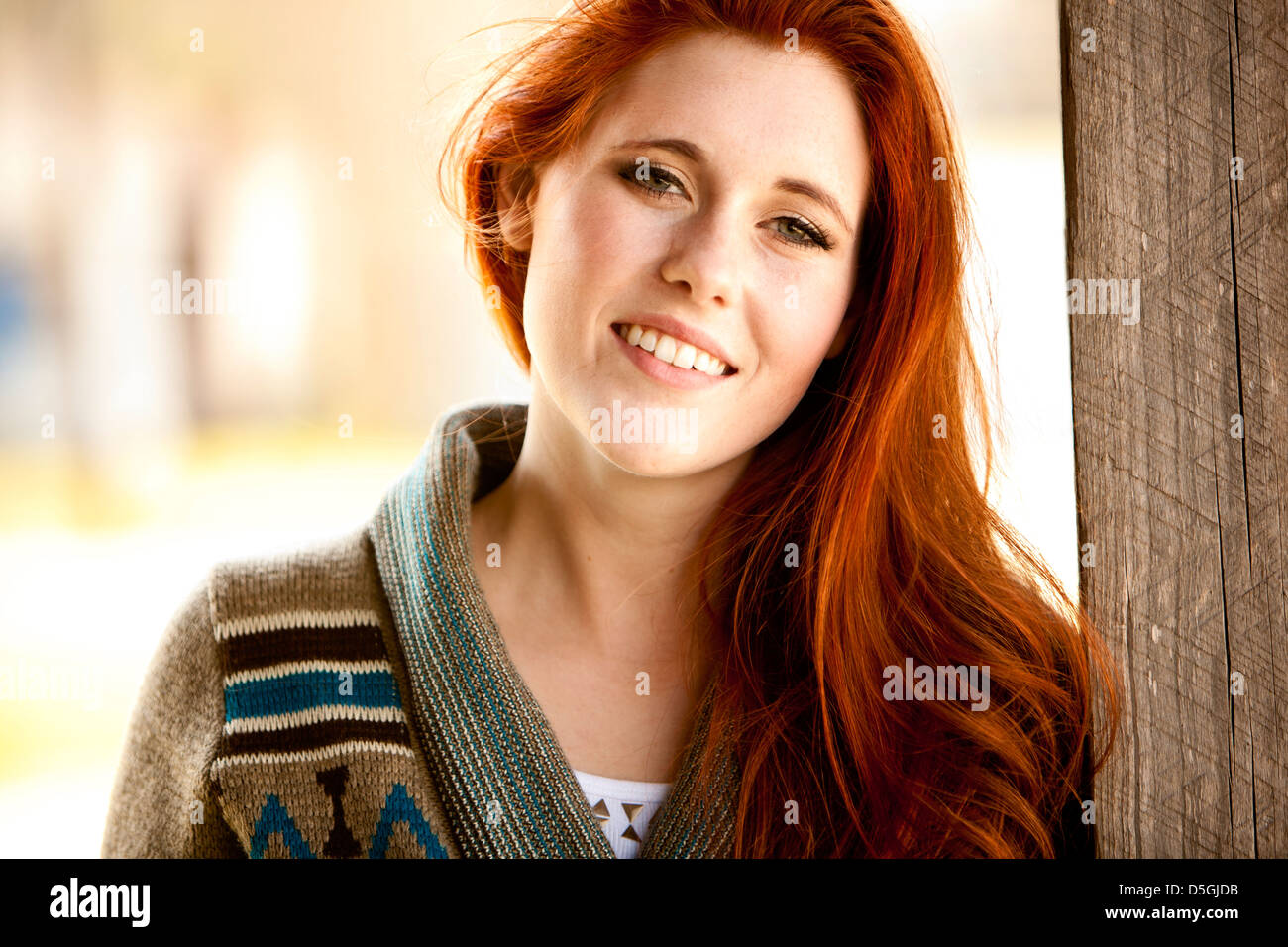Red head woman standing outside in sunlight Stock Photo
