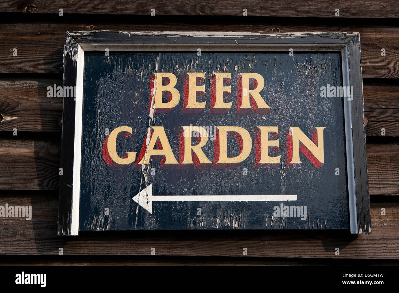 Close up image of hand painted old sign writing of beer garden sign for a Brakespears Pub.Sunshine flaky flaking paint finish. Stock Photo