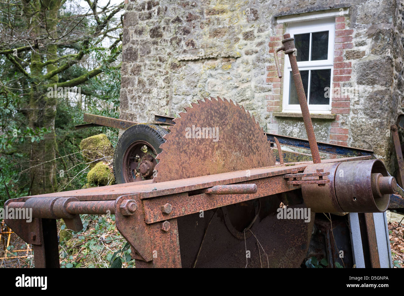 A rusty unused Circular Saw and table left to rust outside Stock Photo