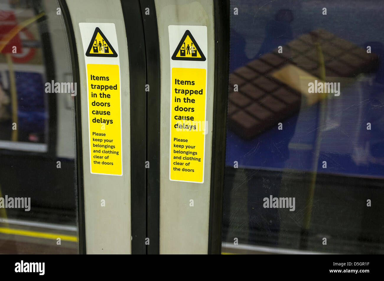 Warning signs on the inside of tube train doors. Stock Photo