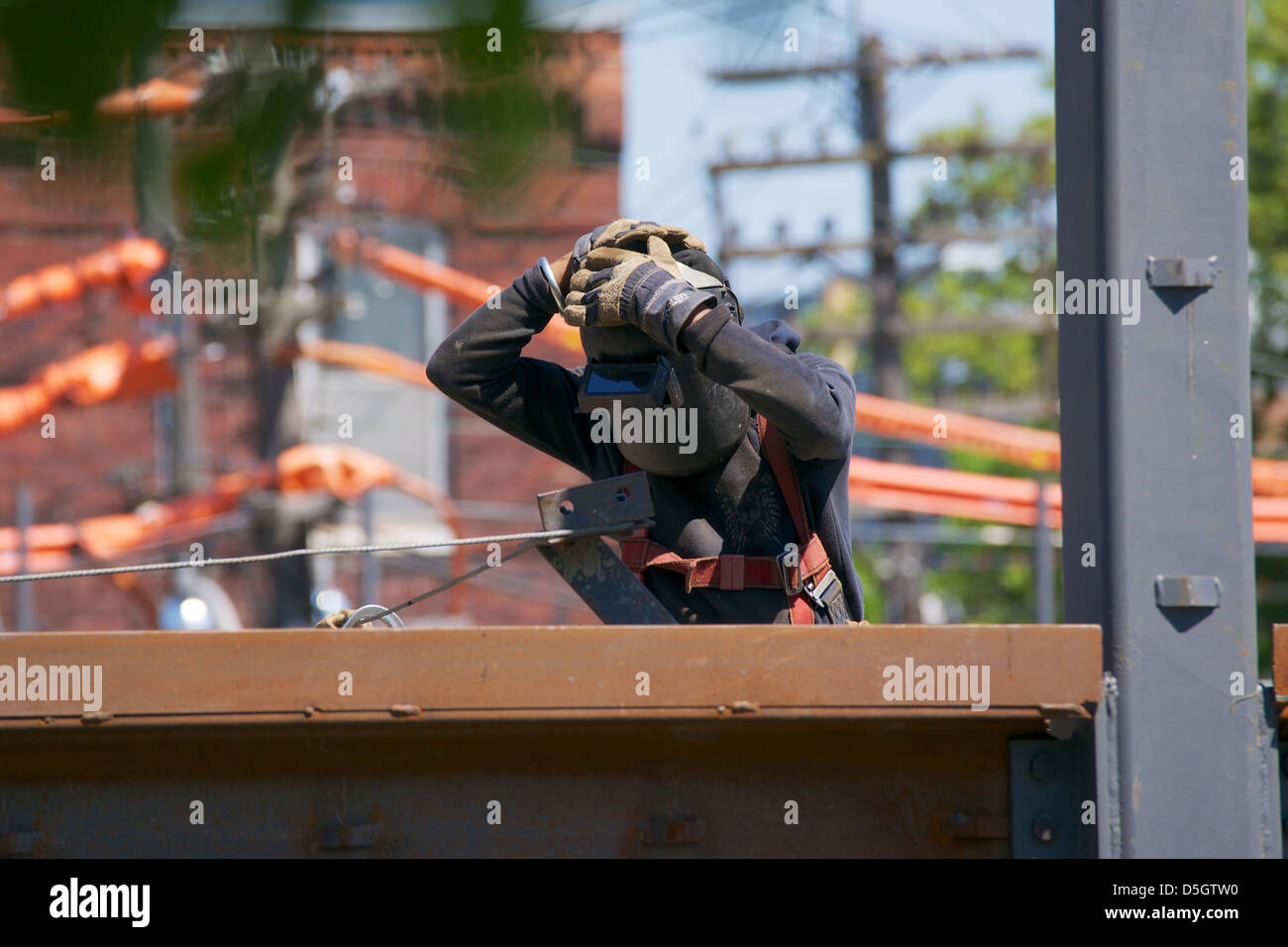 Ironworker putting welding helmet on Stock Photo Alamy