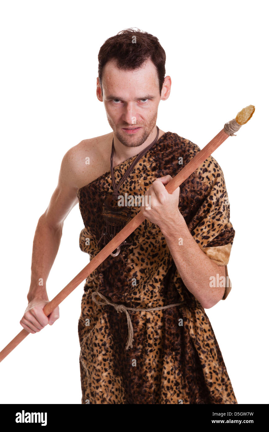 Aggressive man as a savage hunter in skin of a beast with spear isolated on white background Stock Photo