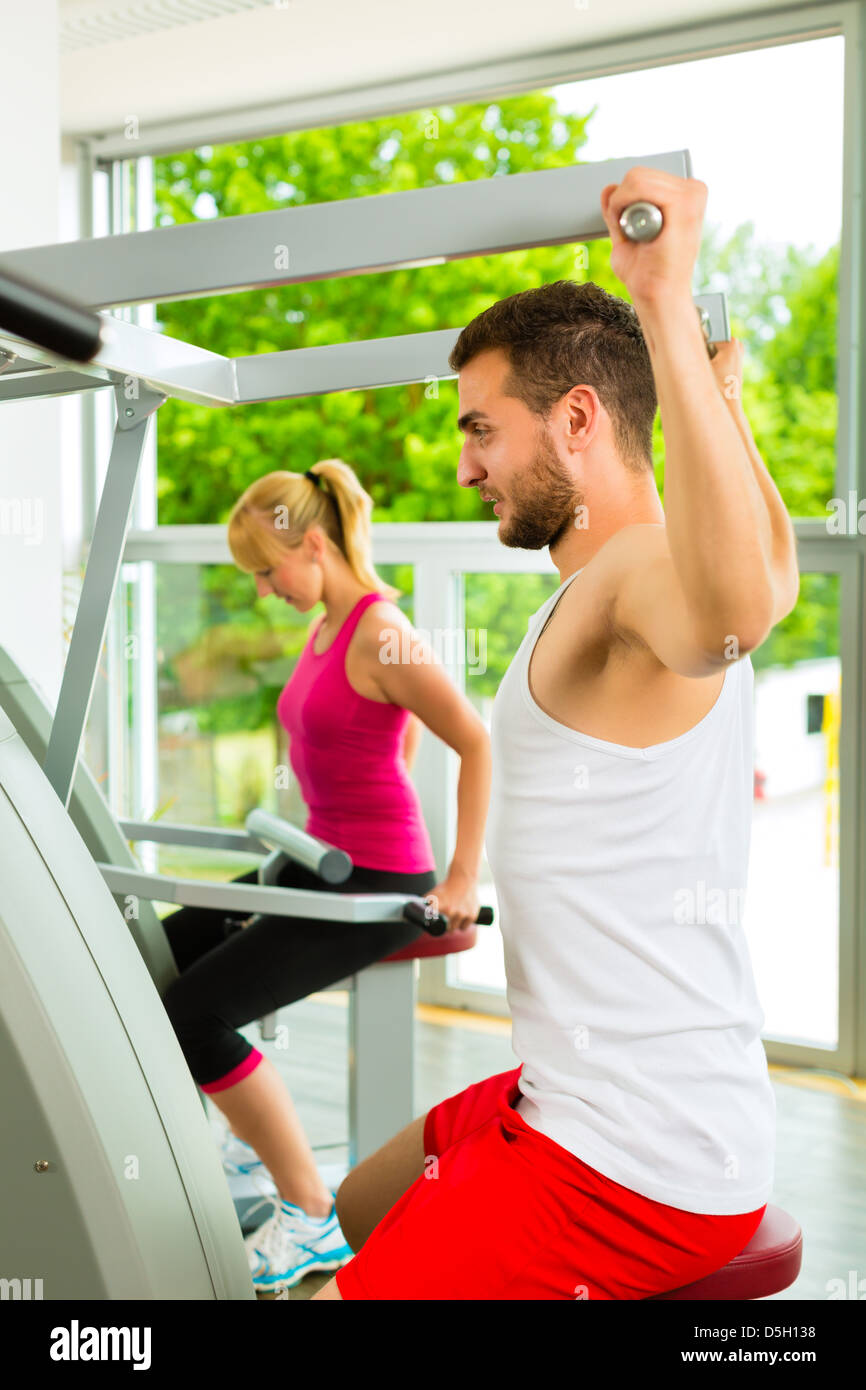 Man and woman train on machine in a fitness club or gym Stock Photo - Alamy