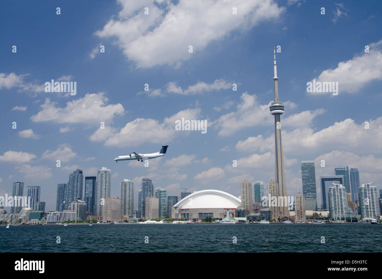 Canada, Ontario, Toronto. Lake Ontario city skyline view of the iconic CN Tower and the Rogers Centre. Porter airplane. Stock Photo