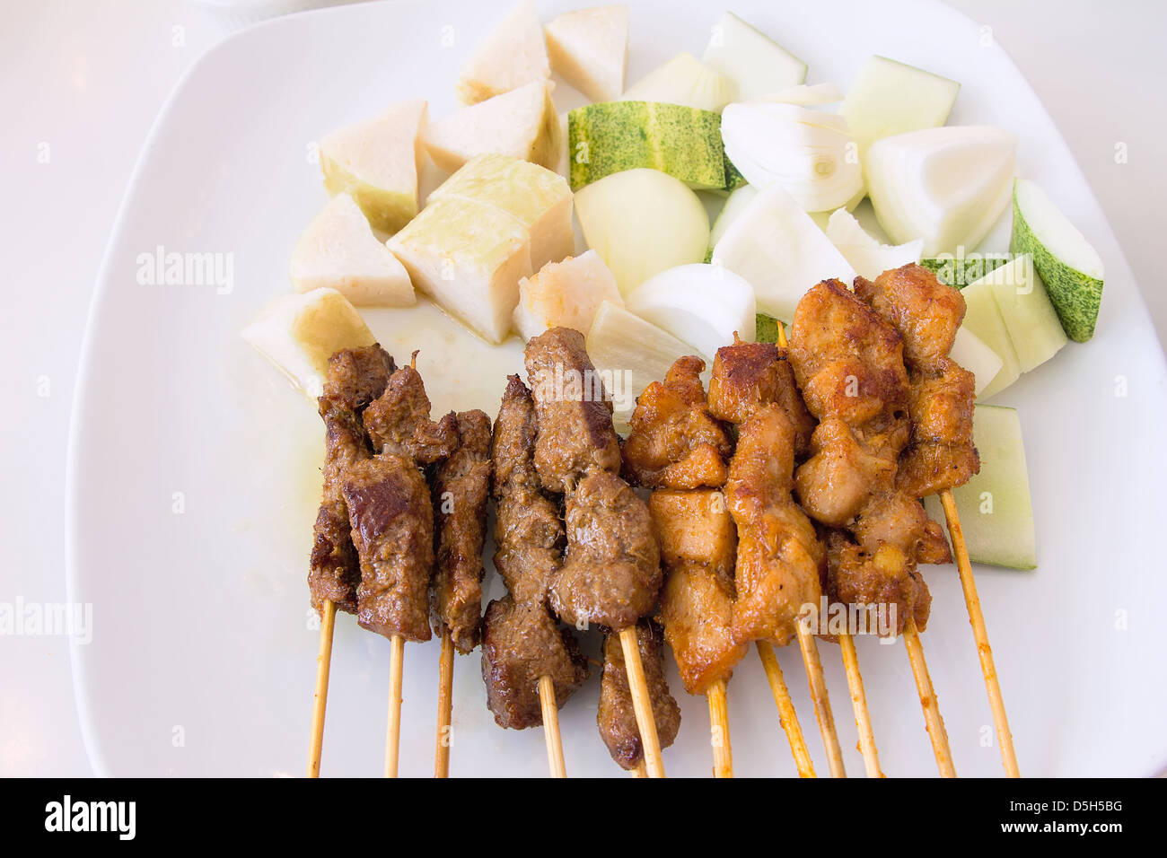 Mutton and Chicken Satay with Chopped Cucumbers Onions and Ketupat Rice Cake Vertical Stock Photo