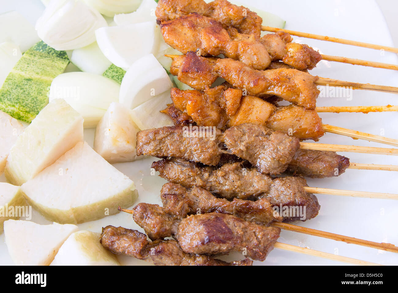 Mutton and Chicken Satay with Chopped Cucumbers Onions and Ketupat Rice Cake Macro Stock Photo