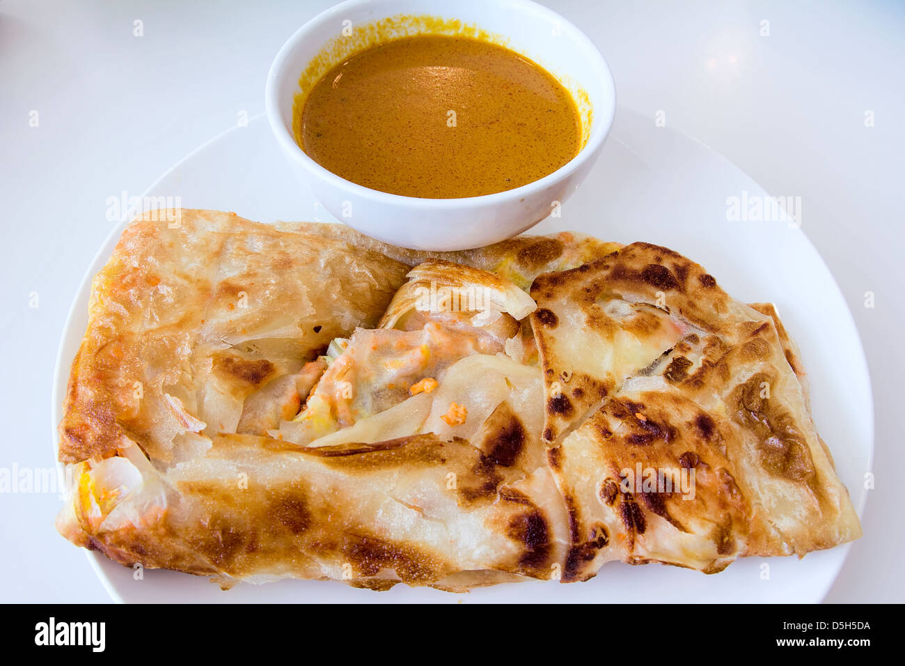 Indian Roti Prata with Chicken Meat and Curry Sauce Stock Photo