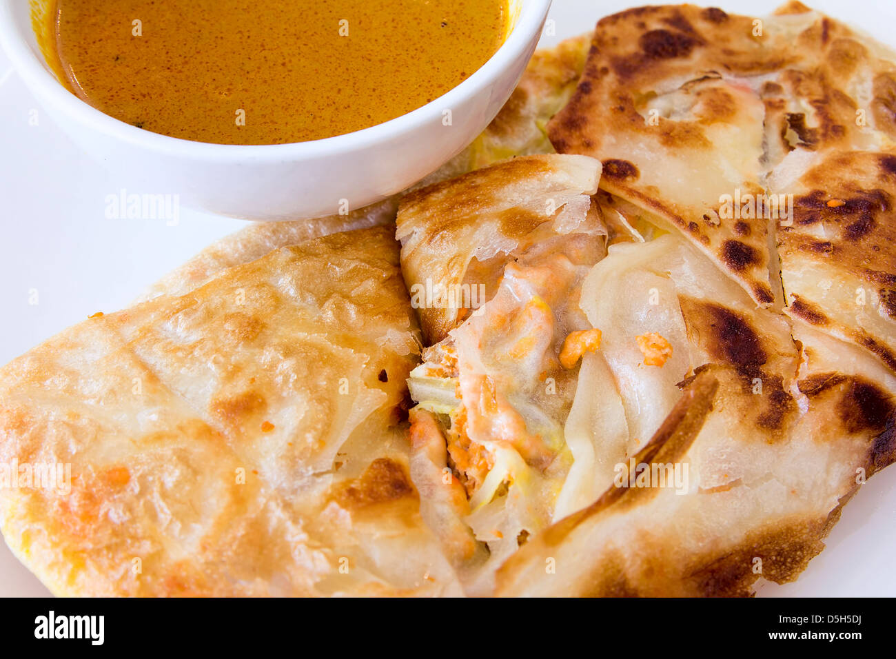 Indian Roti Prata with Chicken Meat and Curry Sauce Closeup Stock Photo