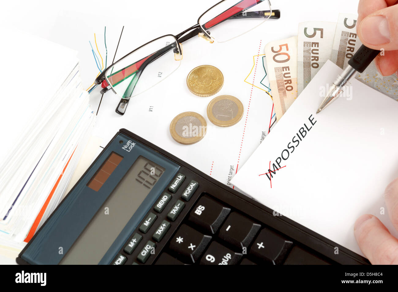 changing impossible word to possible, calculator, charts, pen in hand, money, workplace businessman Stock Photo