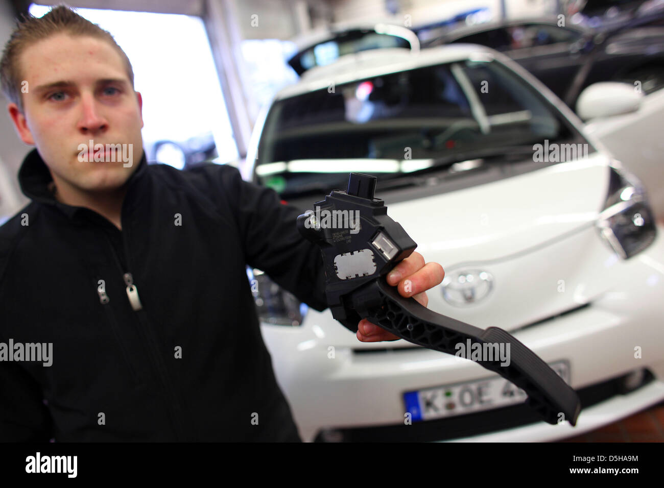 A mechanic of Toyota presents a throttle pedal of a Toyota iQ in Toyota garage in Cologne, Germany, 04 February 2010. A total of 215,796 cars are affected by Toyota's recall campaign due to locking throtel pedals, among them various years of construction of the models AYGO, iQ, Yaris, Auris, Corolla, Verso, Avensis and RAV4. Photo: OLIVER BERG Stock Photo