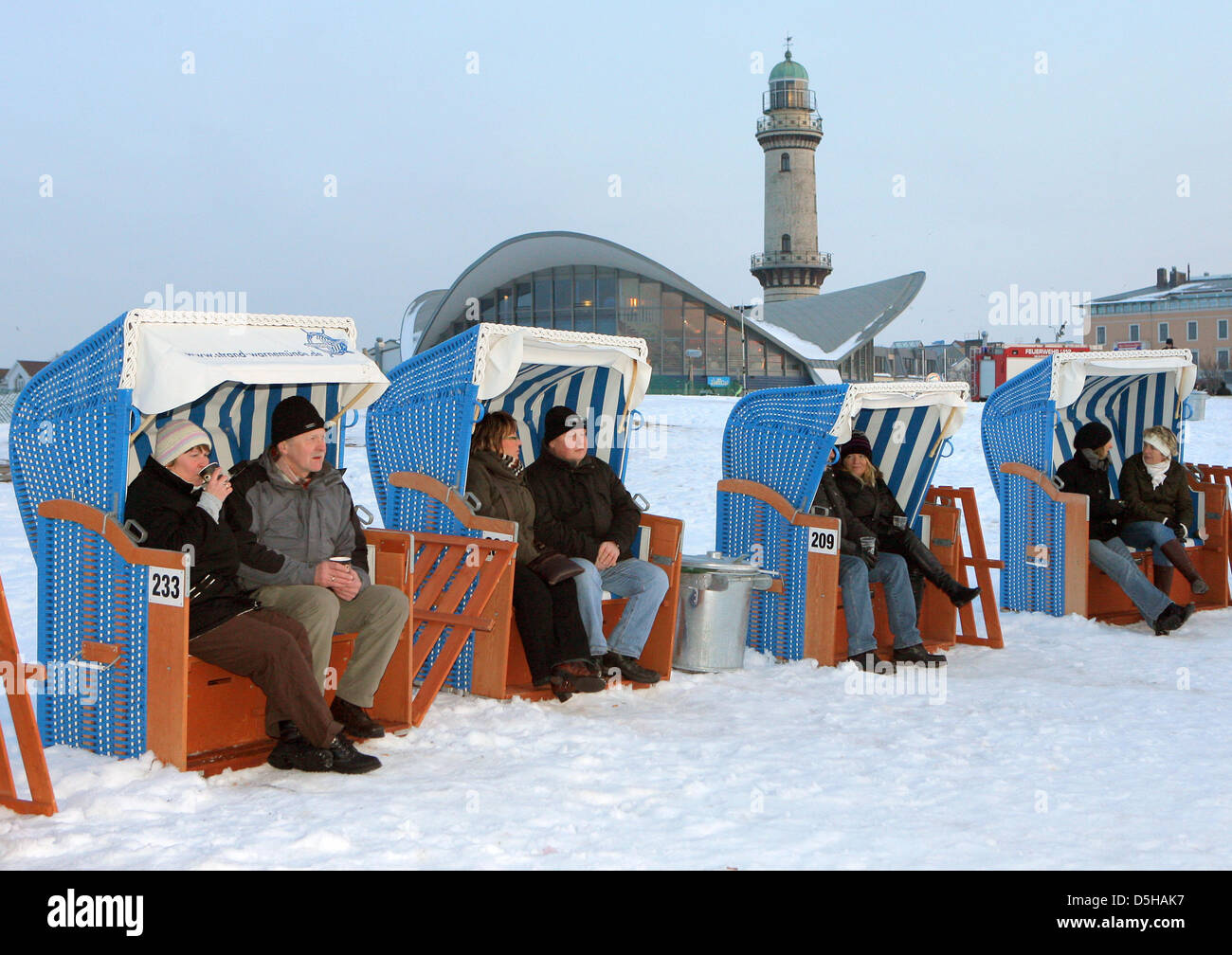 People attend the 'Warnemuende Winter Fun' at the snowy Baltic Sea beach in Warnemuende, Germany, 05 February 2010. Beach fires, beach chairs and gluehwein craeated a pleasurable atmosphere. Photo: Bernd Wuestneck Stock Photo