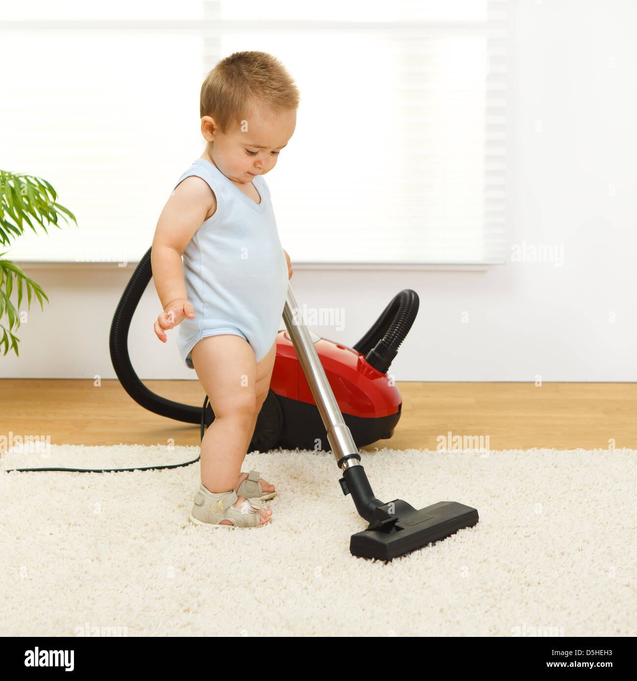 Baby boy cleaning the carpet with vacuum cleaner Stock Photo Alamy
