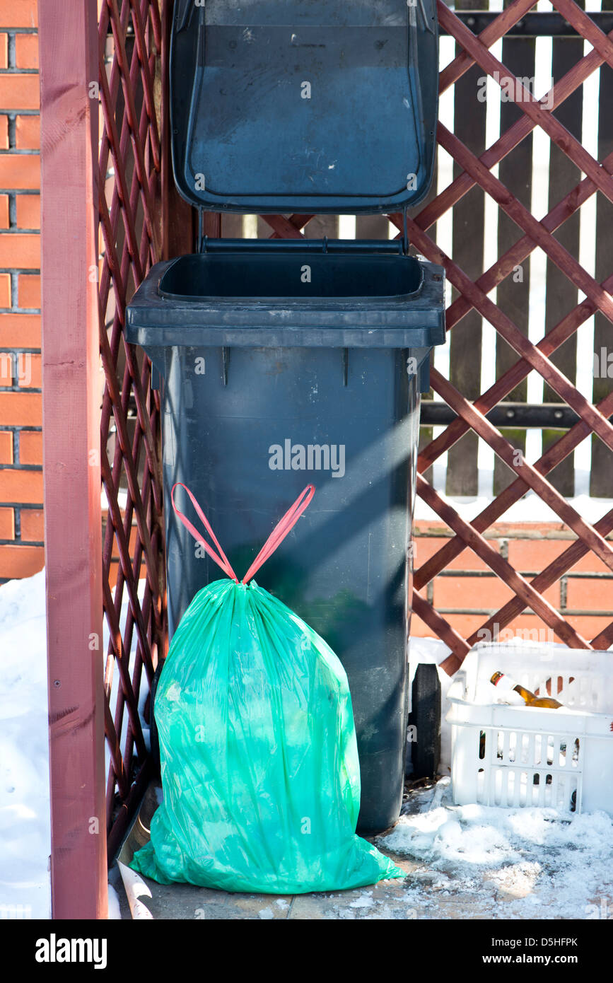 black dirt container for garbage and bag of garbage Stock Photo