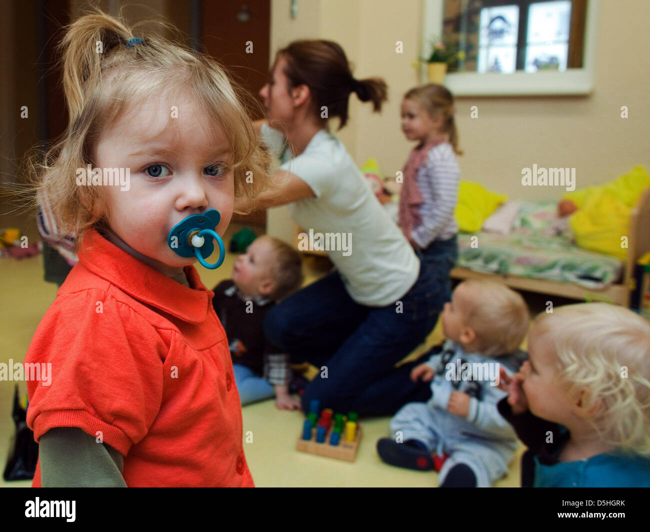 Very young children play with their nanny at the 'Spielhaus