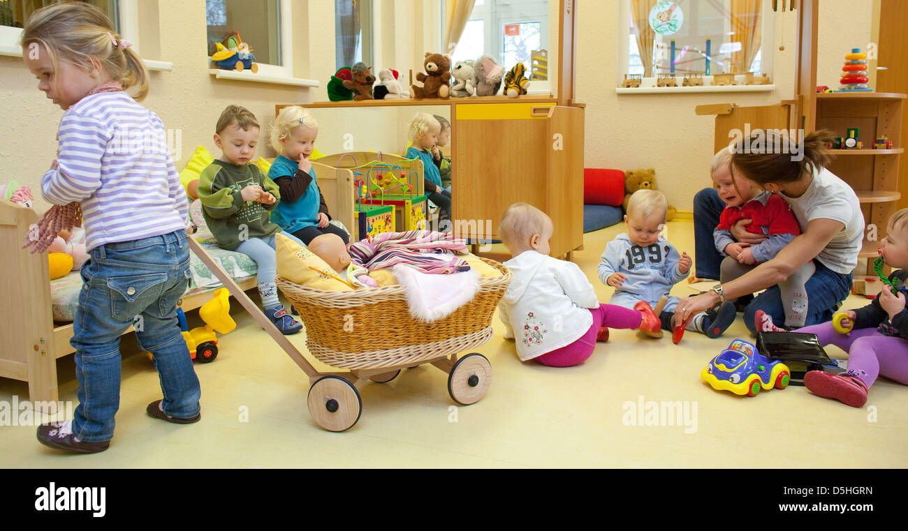 Very young children play with their nanny and social trainees at the ' Spielhaus' ('Playhouse'), a day care centre in Frankfurt Oder, Germany, 15  February 2010. Photo: Patrick Pleul Stock Photo - Alamy