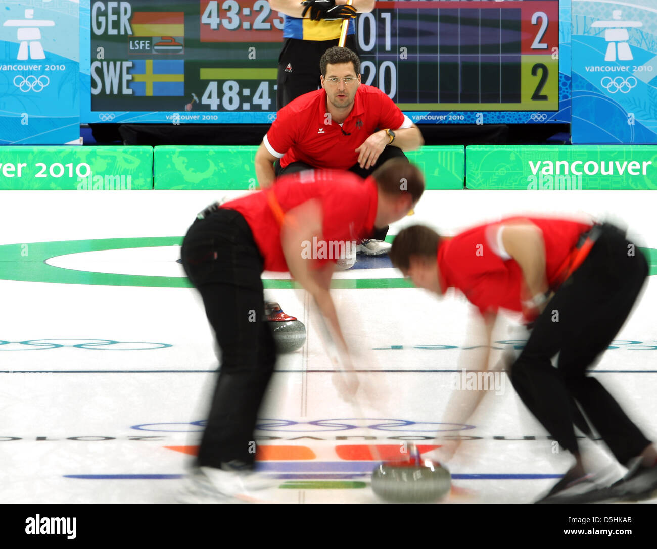 Germany's Holger Hoehne (L) and Andy Lang (R) sweep to guide the stone under instruction of skip Andy Kapp during Curling men's round robin session 3 at the Olympic Center during the Vancouver 2010 Olympic Games in Vancouver, Canada 17 February 2010. Germany's opponent was Sweden. Photo: Daniel Karmann  +++(c) dpa - Bildfunk+++ Stock Photo