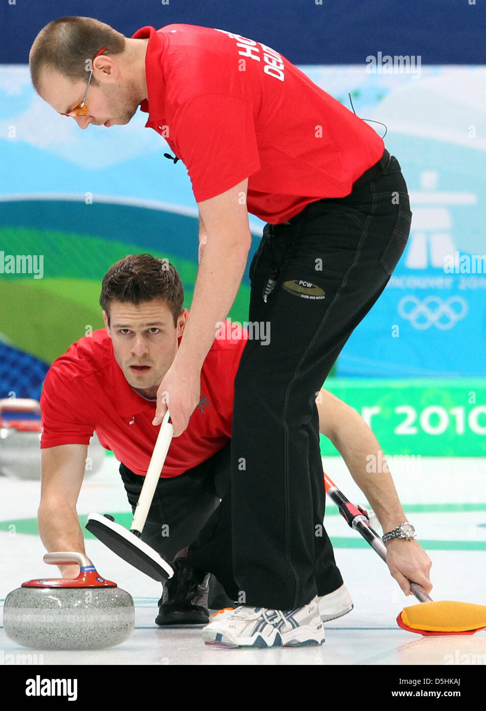 Skip Andy Lang (R) of Germany releases his stone as Holger Hoehne guides it during Curling men's round robin session 3 at the Olympic Center during the Vancouver 2010 Olympic Games in Vancouver, Canada 17 February 2010. Germany's opponent was Sweden. Photo: Daniel Karmann  +++(c) dpa - Bildfunk+++ Stock Photo