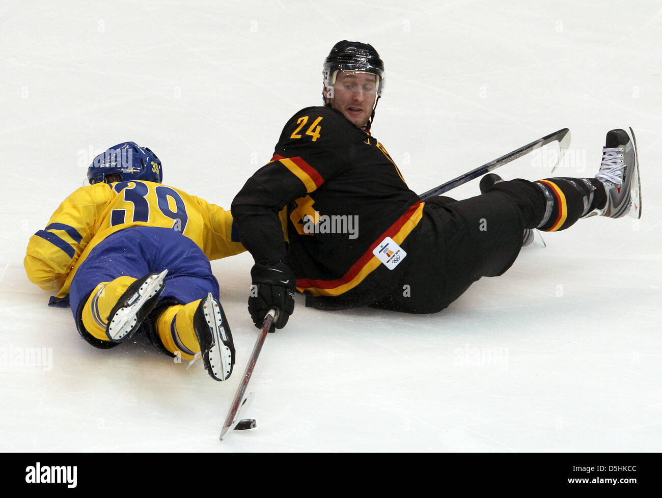 Sweden player Tobias Enstrom (L) falls while going for the puck against Andre Rankel of Germany during the Ice Hockey preliminary round at Canada Hockey Place during the Vancouver 2010 Olympic Games, in Vancouver, Canada, 17 February 2010. Sweden won 2-0. Photo: Daniel Karmann Stock Photo