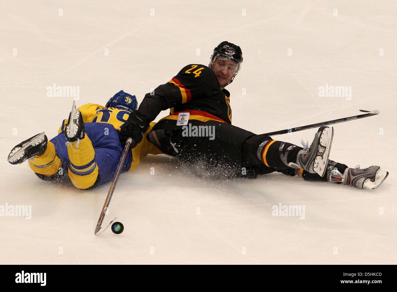 Sweden player Tobias Enstrom (L) falls while going for the puck against Andre Rankel of Germany during the Ice Hockey preliminary round at Canada Hockey Place during the Vancouver 2010 Olympic Games, in Vancouver, Canada, 17 February 2010. Sweden won 2-0. Photo: Daniel Karmann  +++(c) dpa - Bildfunk+++ Stock Photo