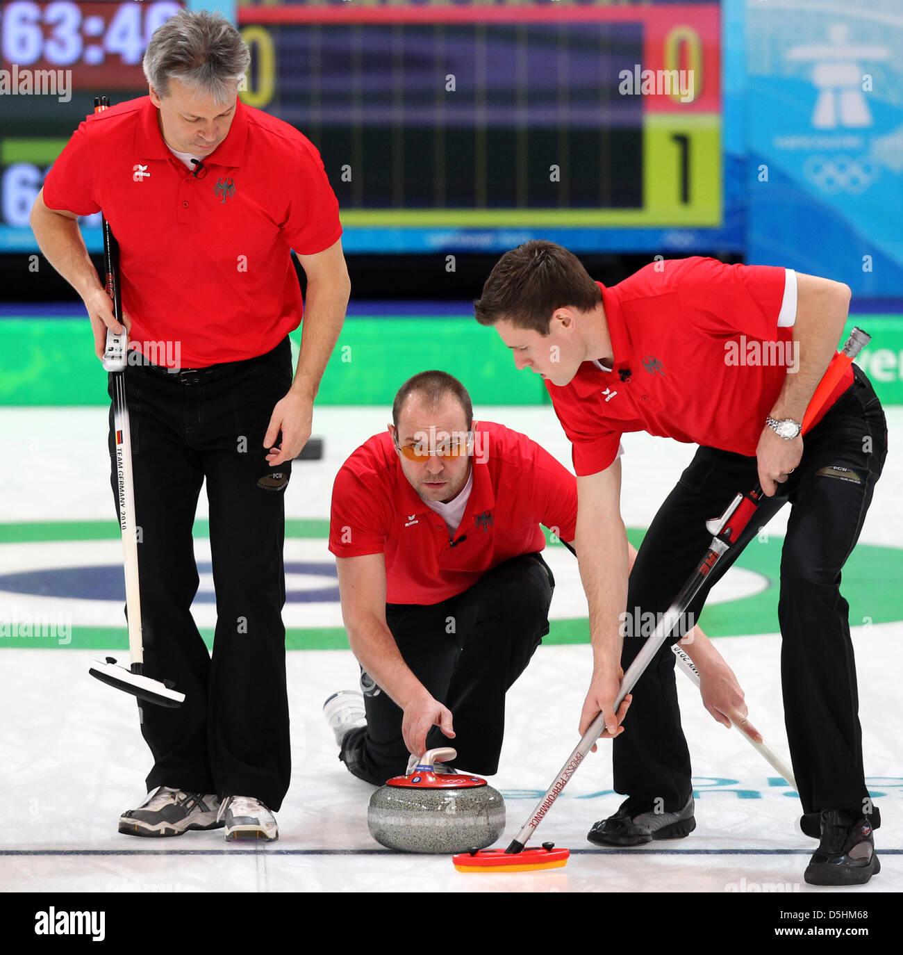 Germany's Andy Kempf (C) plays his stone as teammate Andy Lang (R) sweeps and Holger Hoehne looks on during their curling men's round robin session 4 against Norway during the Vancouver 2010 Olympic Games at the Vancouver Olympic Center in Vancouver, Canada 18 February 2010. Photo: Daniel Karmann  +++(c) dpa - Bildfunk+++ Stock Photo