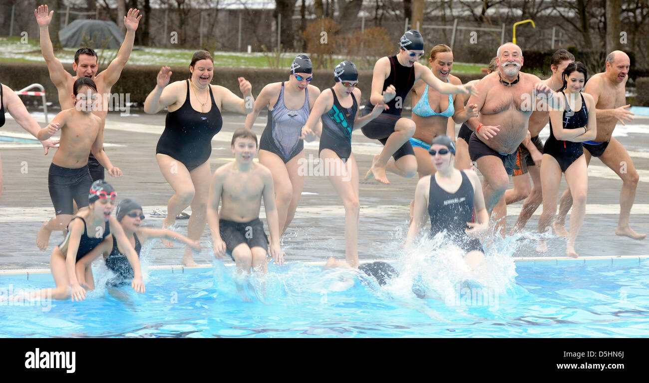 Visitors of the outdoor pool ''Sonnenbad'' jump into the water in Karlsruhe, Germany, 20 February 2010. According to the organizer it is the first open-air-baths with the longest operation time this year in Germany. ''The water temperatures are adjusted to the air temperature, so that they are in a pleasant ratio and increase wellness'', the city advertises their partly roofed pool Stock Photo