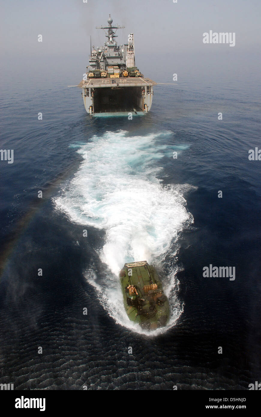 A US Navy amphibious assault vehicle departs the well deck of the amphibious dock landing ship USS Rushmore during an exercise Mar. 29, 2013 in the Arabian Sea. Green Bay is part of the Peleliu Amphibious Ready Group and, with embarked 15th Marine Expeditionary Unit, is deployed in support of maritime security operations and theater security cooperation efforts in the U.S. 5th Fleet area of responsibility. Stock Photo