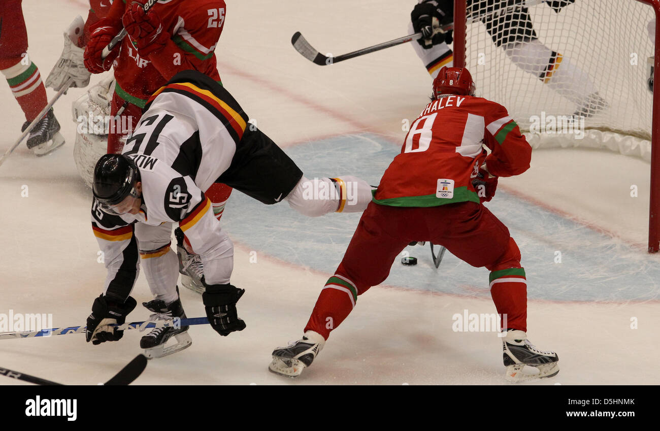 Travis Mulock (L) of Germany fights for the puck with Andrei Mikhalev of Belarus during Ice Hockey preliminary round of group C game 15 in Canada Hockey Place, Vancouver, Canada, 20 February 2010. Photo: Daniel Karmann  +++(c) dpa - Bildfunk+++ Stock Photo