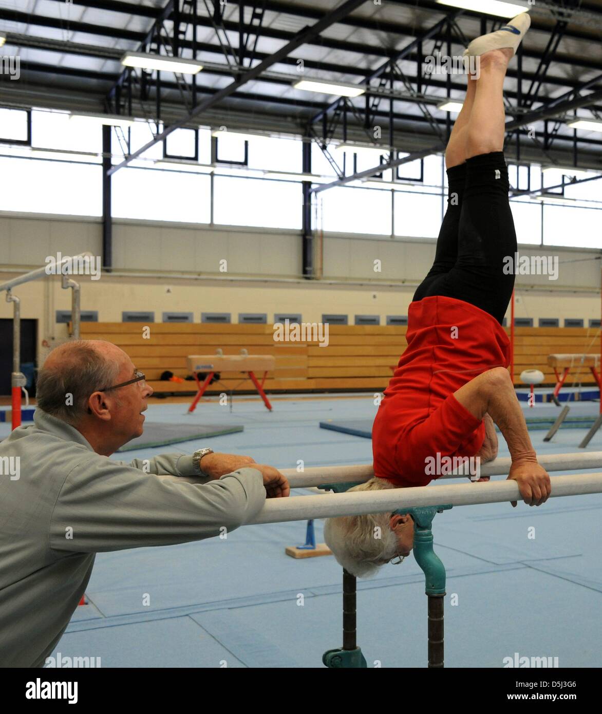 86-year-old Johanna Quaas, the world's oldest gymnast, is supported by her husband,former gymnast trainer Gerhard Quaas, during her weekly training on the bars in Halle, Germany, 06 November 2012. The agile gymnast, whose birthday is on 20 November, does sport acitivities every day and still participates in competitions. As the oldest active gymnast, she is listed in the Guinness B Stock Photo