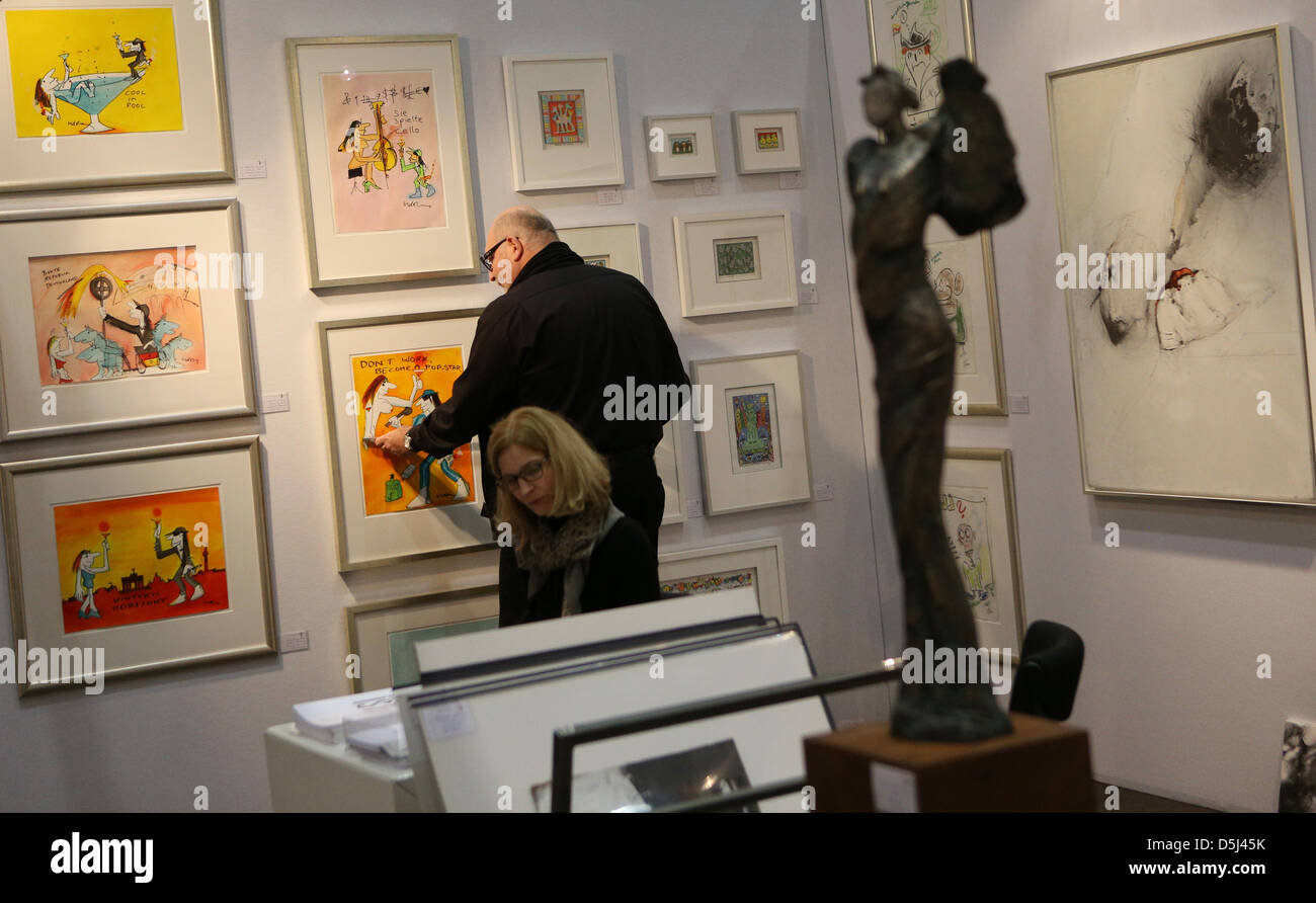 A man measures a painting by musician and artist Udo Lindenberg at the exhibition booth of Gallery Jaeschke at the art fair 'Affordable Art Fair' in Hamburg, Germany, 14 November 2012. After stops in innternational metropoles, Affordable Art Fair opens its doors in Germany for the first time. 56 international galleries will present works by contemporary artists from 15 November til Stock Photo