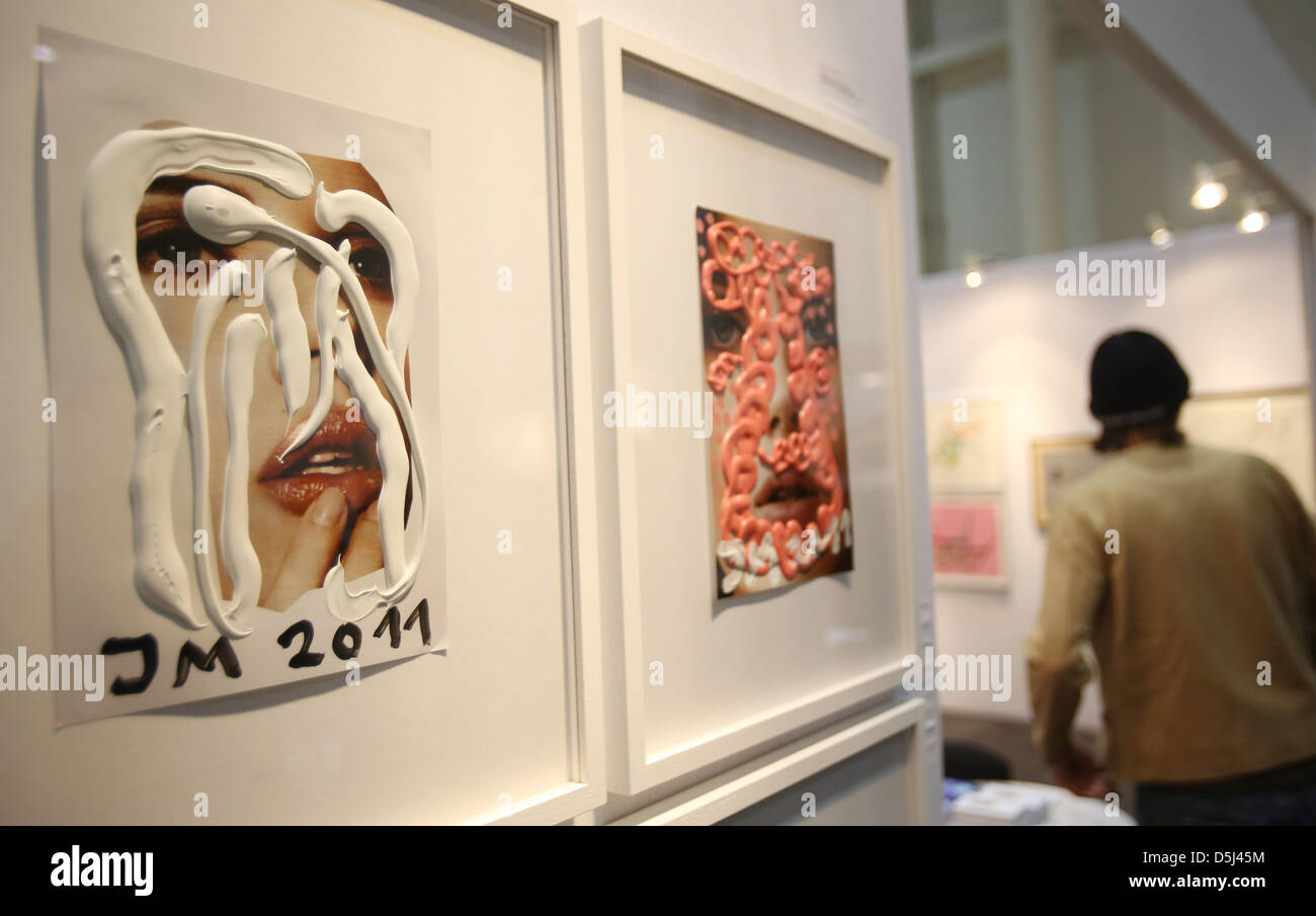 A visitor stands next to the works 'Erzfraeulein Erzhormoni' by Jonathan Meese at the exhibition booth of Gallery St. Gertrude at the art fair 'Affordable Art Fair' in Hamburg, Germany, 14 November 2012. After stops in innternational metropoles, Affordable Art Fair opens its doors in Germany for the first time. 56 international galleries will present works by contemporary artists f Stock Photo