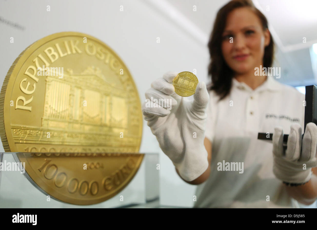 A Women Presents A Small Coin And Europe S Largest Gold Coin At An Stock Photo Alamy