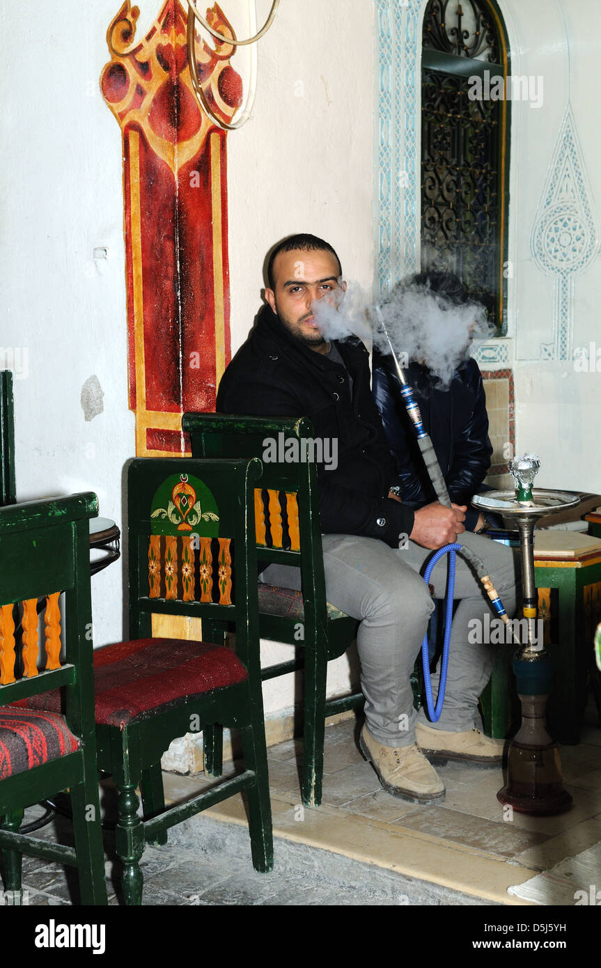 Tunisian man smoking a shisha in a cafe  in the old Medina Tunis Tunisia Stock Photo