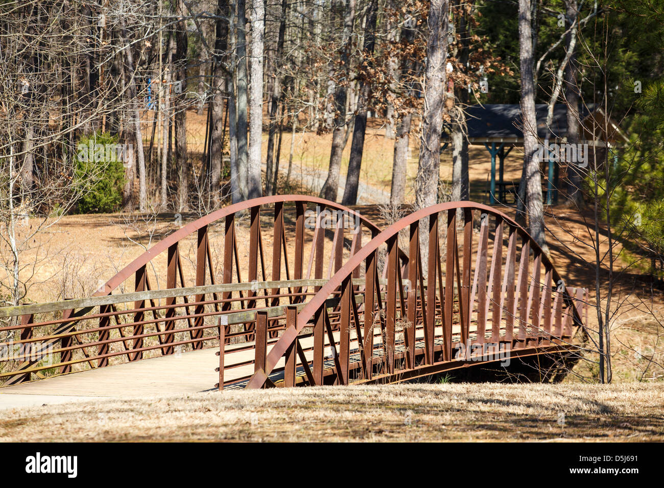 An old bridge across a stream in a public park in winter Stock Photo ...