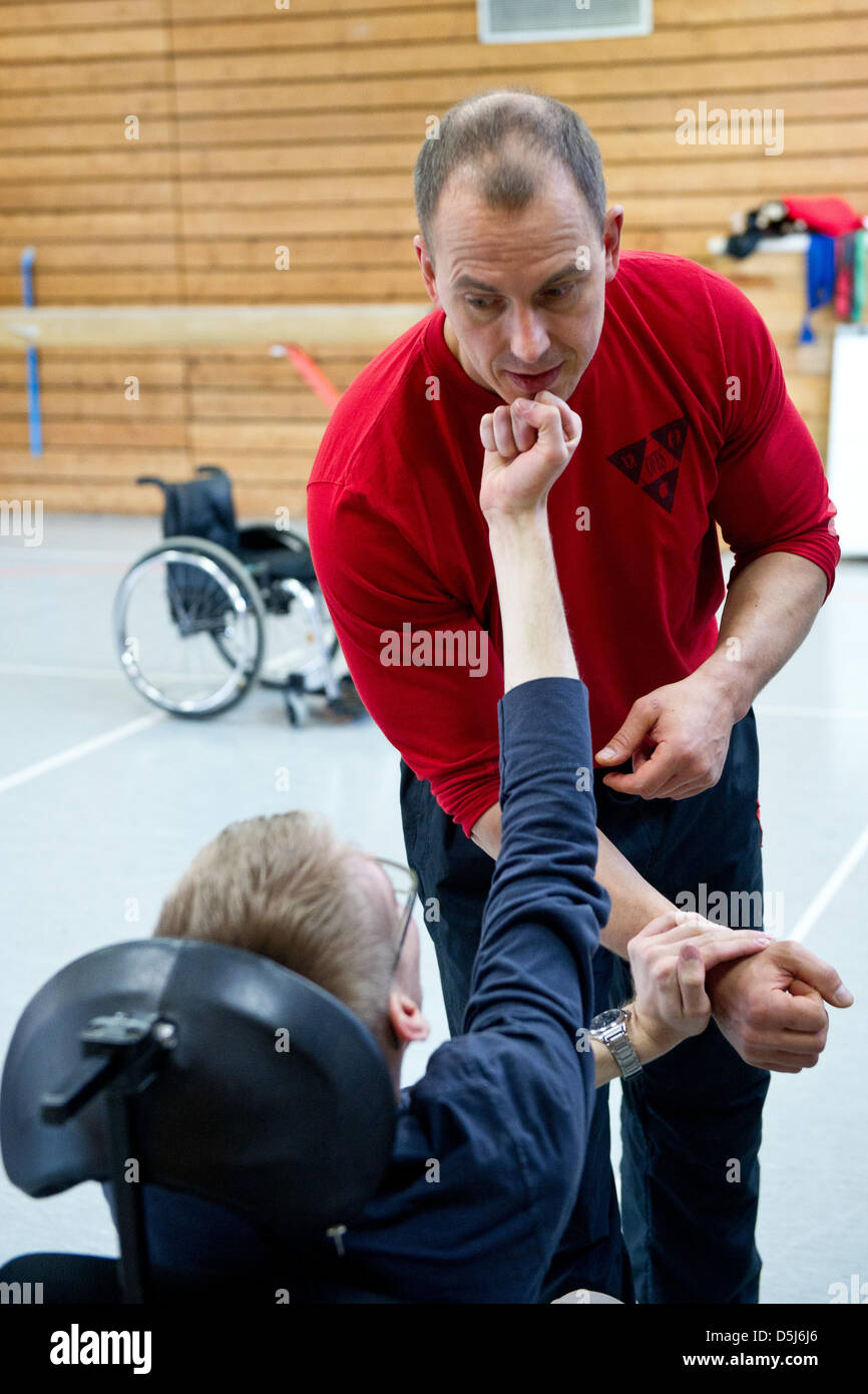 Coaches Nils Thate teach defence techniques to a person in wheel chairs in Langenhagen, Germany, 11 November 2012. Coaches Bernd Rosemann and Nils Thate give self-defence courses for people in wheel chairs. Photo: Tobias Kleinschmidt Stock Photo
